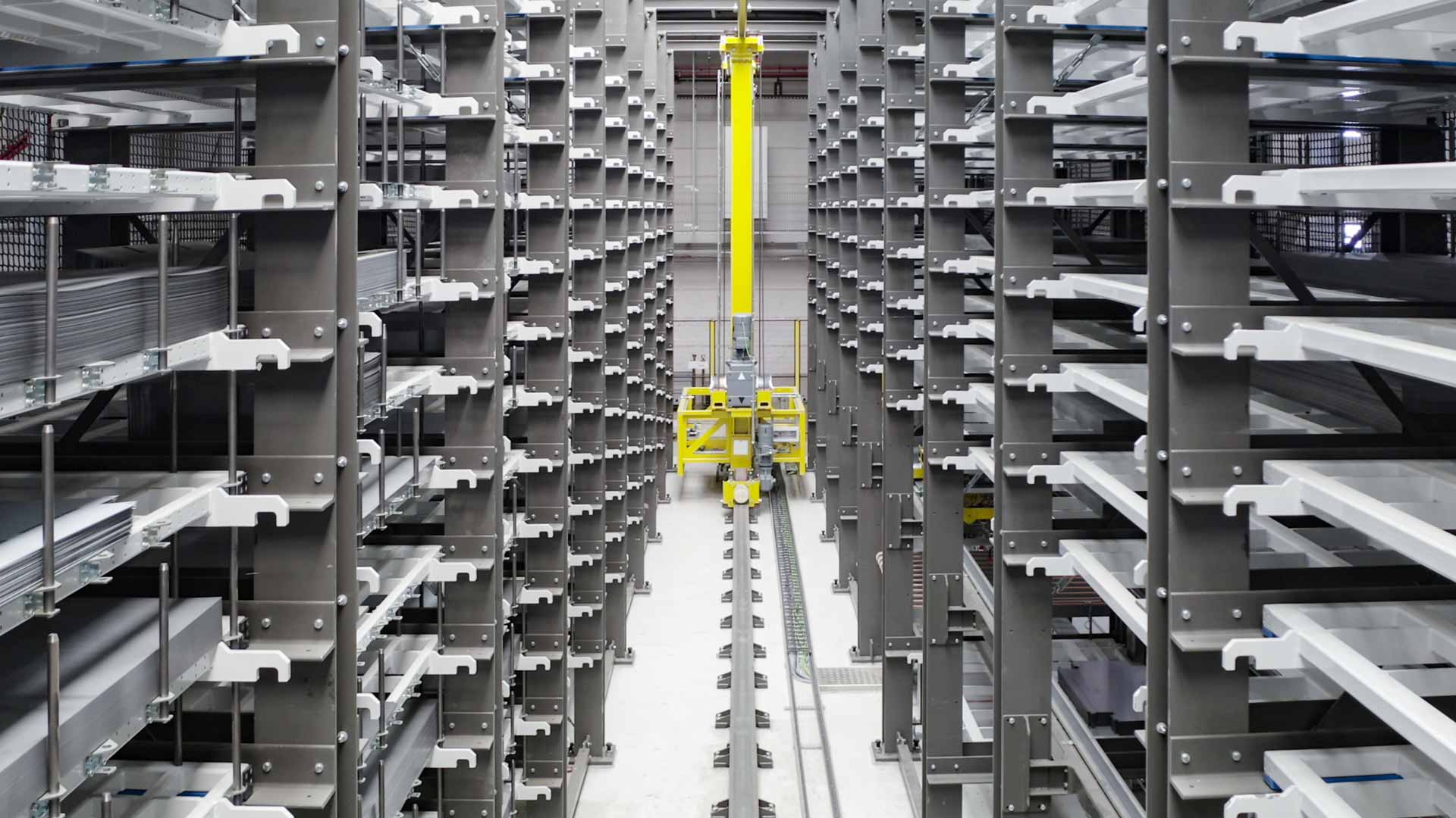 Automatisches Hochregallager von C&nbsp;+&nbsp;P mit gelbem Regalbediengerät zwischen den Regalreihen
